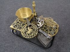 A tray of antique metal ware including brass trivets, fire dog, cast iron handled pan,