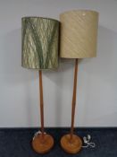 A pair of mid 20th century (Ercol?) teak standard lamps with non-matching shades