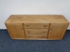 An Ercol solid elm double door sideboard with three central drawers, catalogue no.