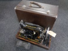 A cased 20th century Singer electric sewing machine with lead