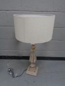 A contemporary wooden table lamp with beige shade