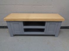 A contemporary entertainment stand with painted base fitted cupboards and shelves below (no