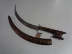 A 20th century North African Nimcha short sword with hardwood and brass handle and sheath