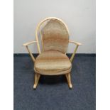 An Ercol solid elm and beech Windsor tub rocking chair, catalogue no.