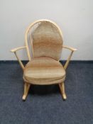 An Ercol solid elm and beech Windsor tub rocking chair, catalogue no.