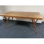 A contemporary teak dining table on splayed legs