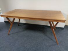 A contemporary teak dining table on splayed legs