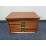 A 20th century hardwood desk top five drawer chest with brass drop handles