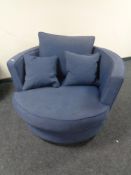 A revolving cuddle chair with loose cushions in a blue fabric