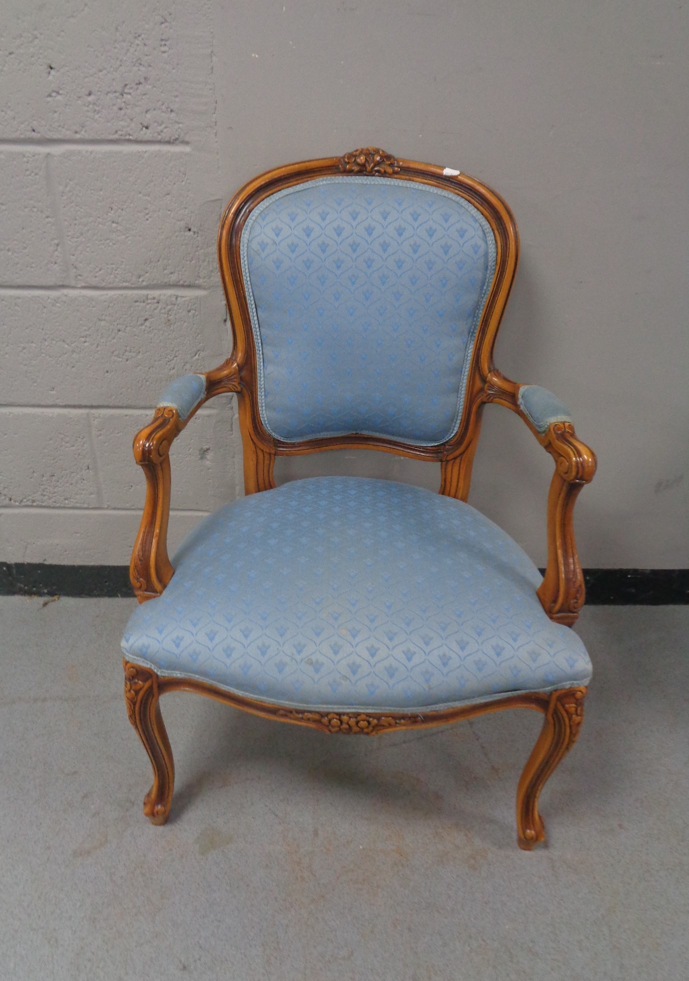 A carved beech framed salon armchair in blue fabric