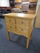 A contemporary oak four drawer chest on raised legs