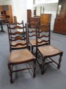 A set of four early twentieth century ladder backed rush seated kitchen chairs