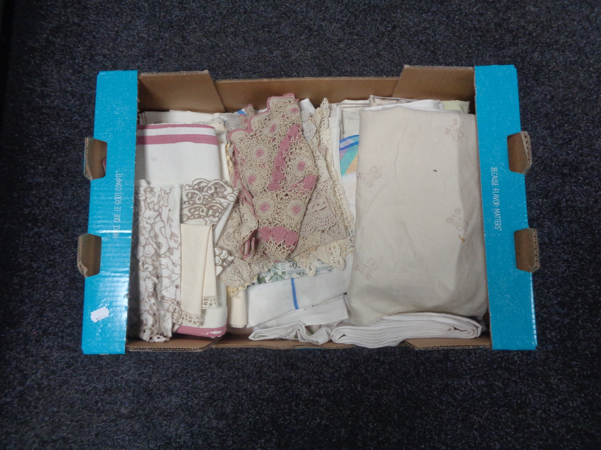A box of assorted table linen, lace pieces,