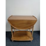 An Ercol elm and beech three tier flap-sided tea trolley, catalogue no.