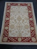 A machine made woolen rug of floral design on cream ground