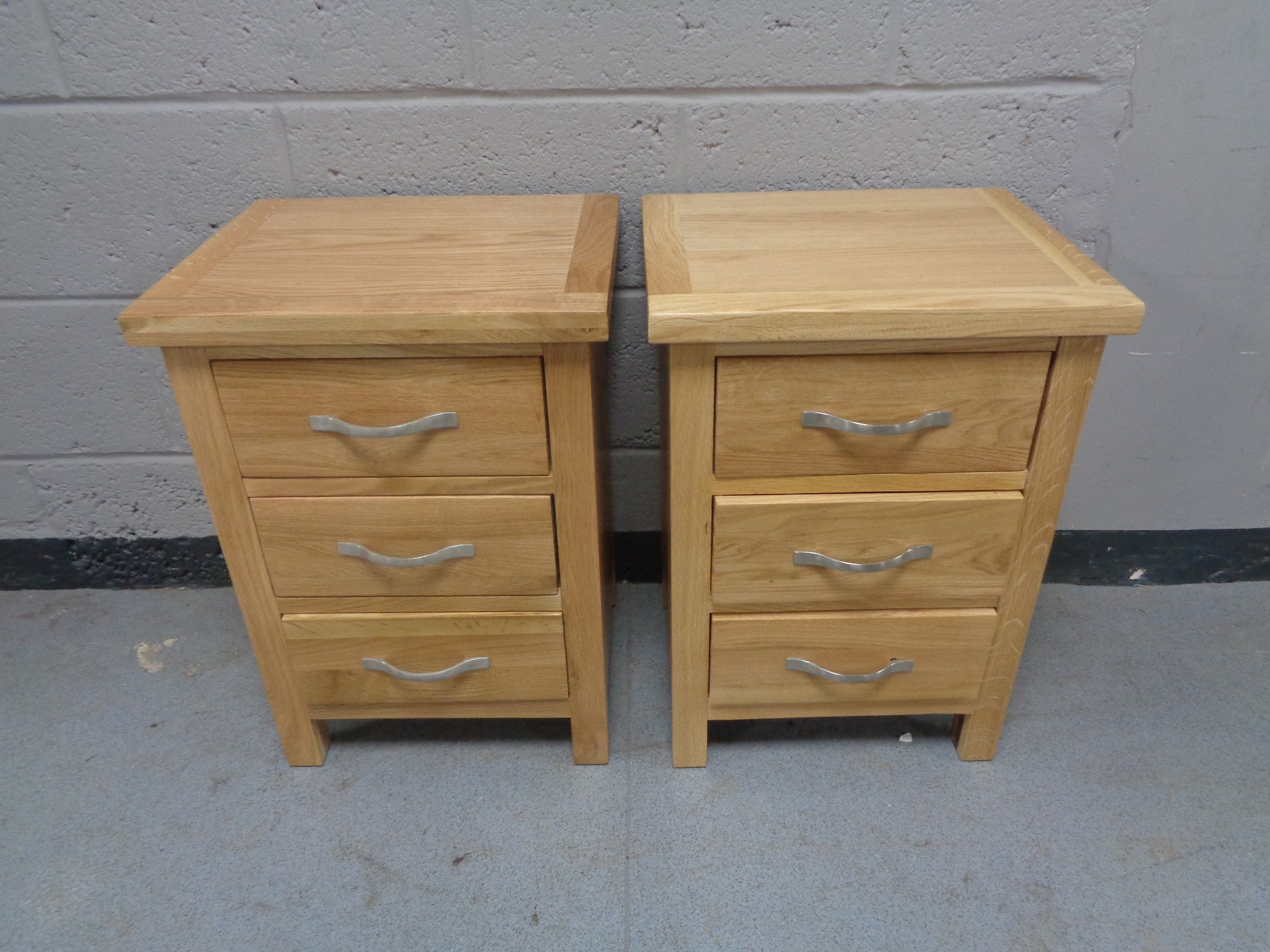 A pair of contemporary pine three drawer bedside chests