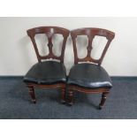 A pair of antique mahogany black leather seated dining chairs