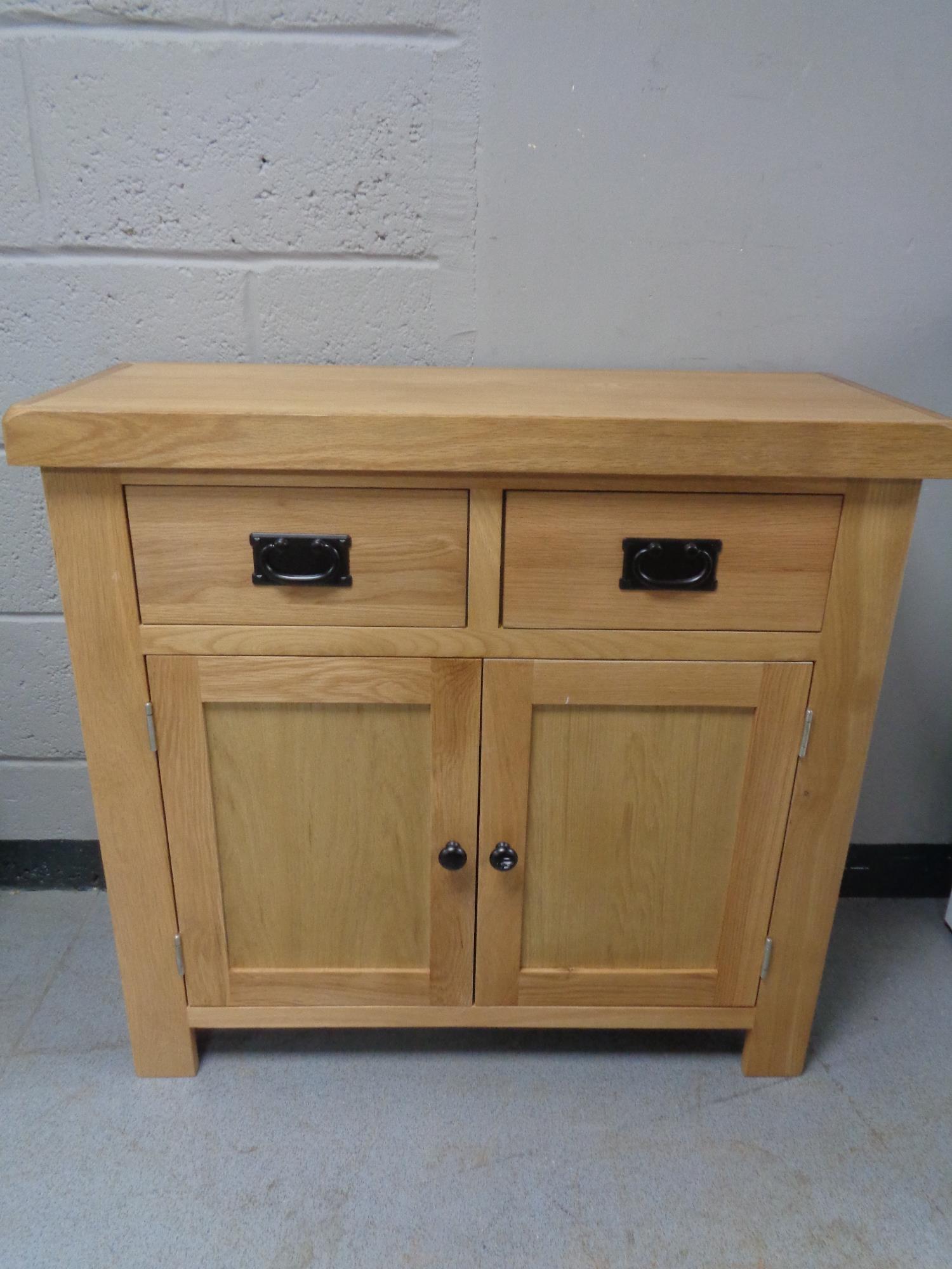 A contemporary oak double door cabinet fitted two drawers (a/f)