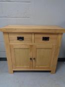 A contemporary oak double door cabinet fitted two drawers (a/f)