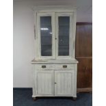 A painted Edwardian double door glazed bookcase fitted cupboards and drawers beneath