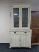 A painted Edwardian double door glazed bookcase fitted cupboards and drawers beneath
