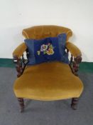 An Edwardian mahogany tub chair in mustard buttoned fabric and a cushion