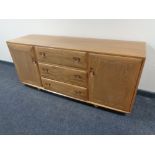 An Ercol solid elm sideboard with double doors and three central drawers, length 155cm, height 68cm,
