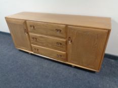 An Ercol solid elm sideboard with double doors and three central drawers, length 155cm, height 68cm,