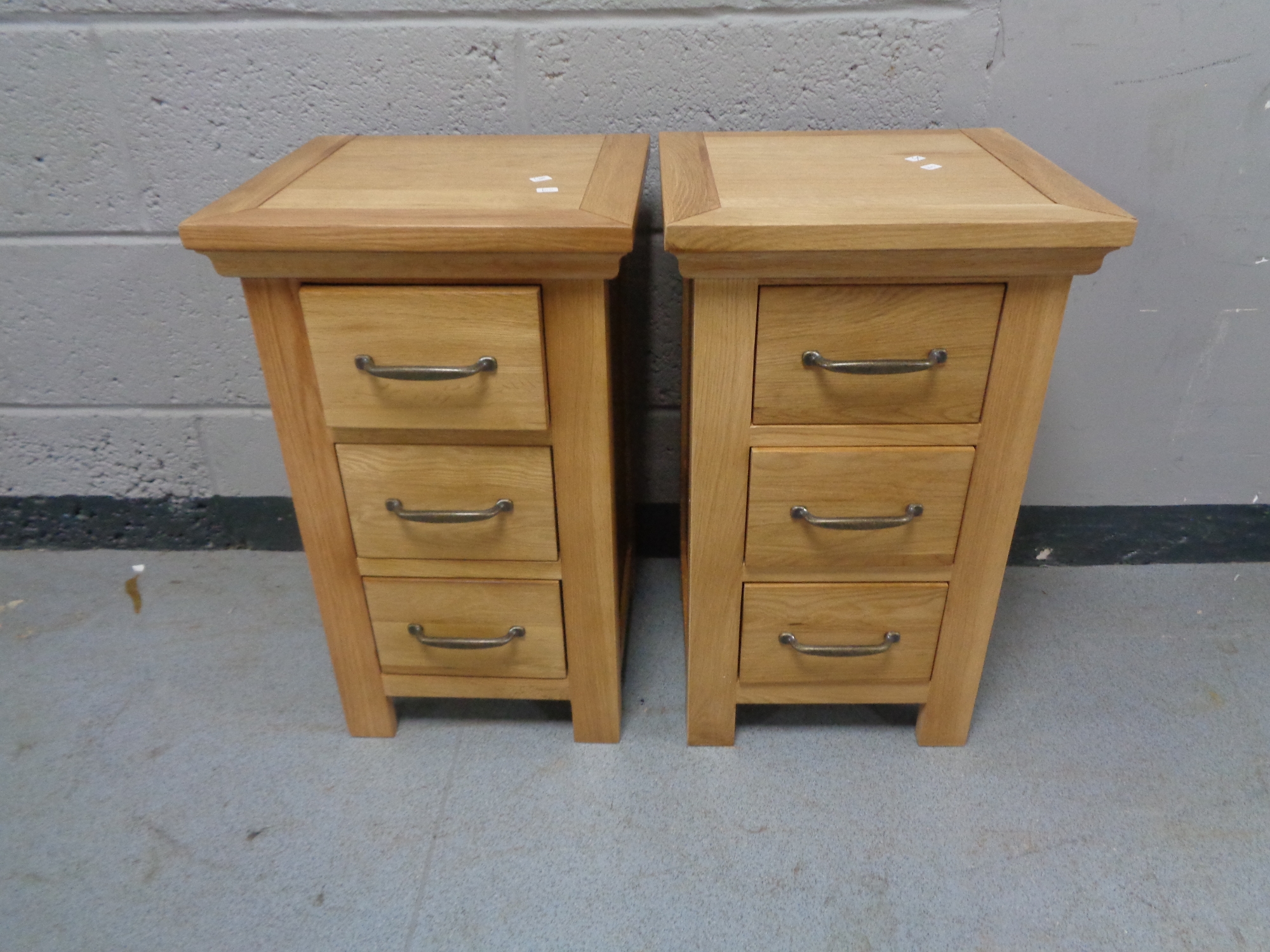 A pair of contemporary oak three drawer bedside chests