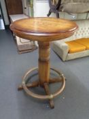 A twentieth century circular pedestal poser table with foot rail