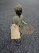 An Indian bronze figure depicting a servant carrying a shell-shaped tray