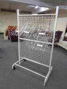 A portable wire metal shop display stand with adjustable tray shelves