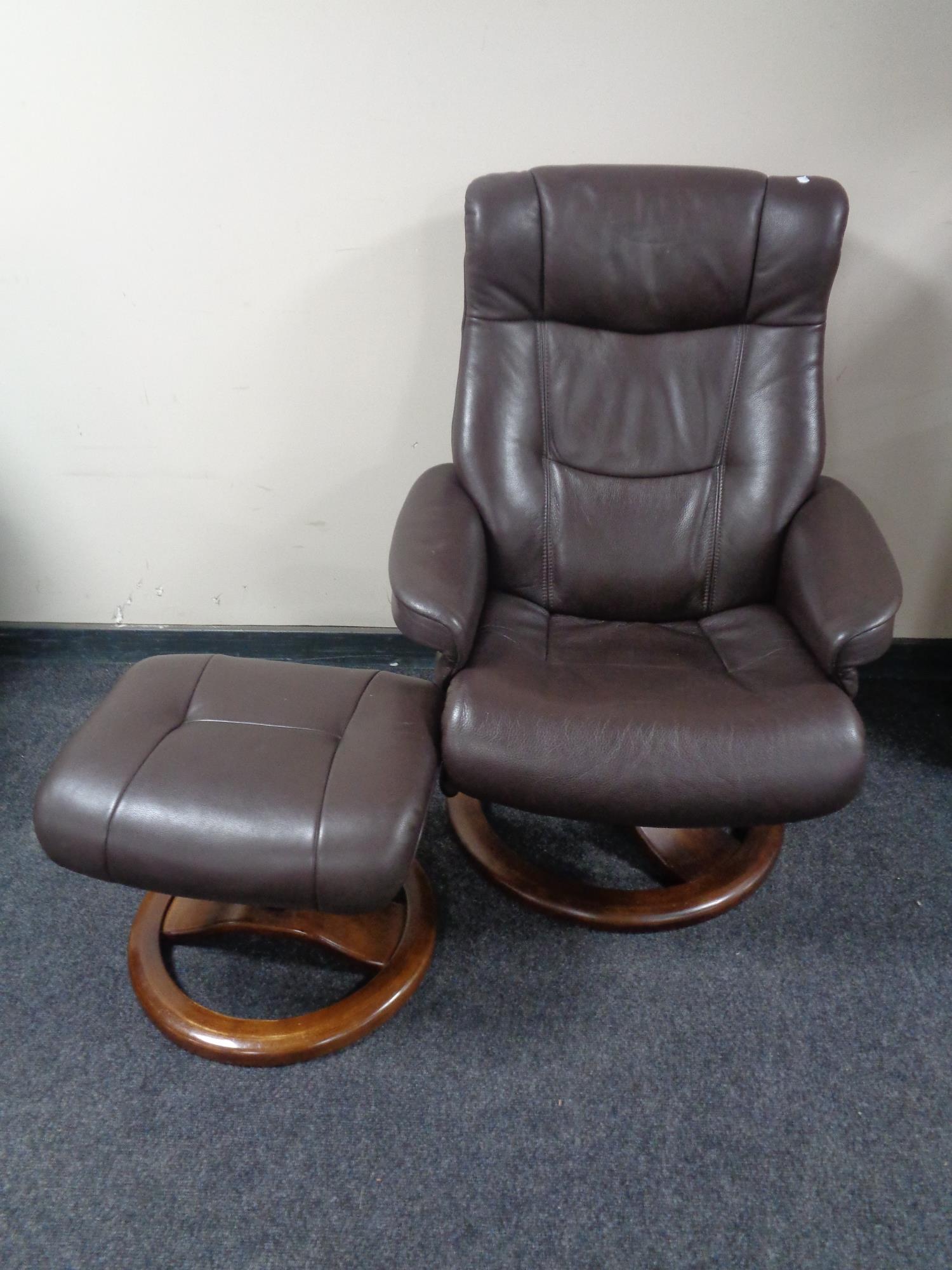 A brown leather armchair with stool