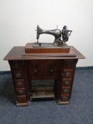 An early 20th century sewing machine cabinet and a hand sewing machine