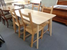 A contemporary Ikea dining table and four pine chairs