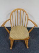 An Ercol solid elm Windsor tub rocking chair, catalogue no.