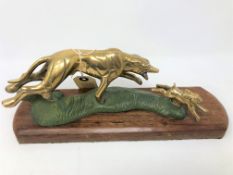 An early twentieth century brass figure of a hare and hound, on mahogany plinth, width 34 cm.