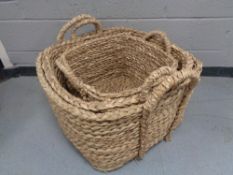 A set of three large graduated wicker baskets with handles