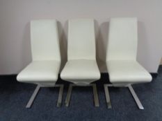 A set of seven cream leather contemporary dining chairs on chrome feet