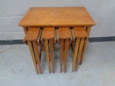 A late 20h century nest of five teak tables