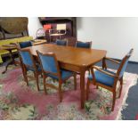 A mid 20th century teak extending dining table and six chairs (two carvers and four singles)