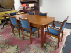 A mid 20th century teak extending dining table and six chairs (two carvers and four singles)