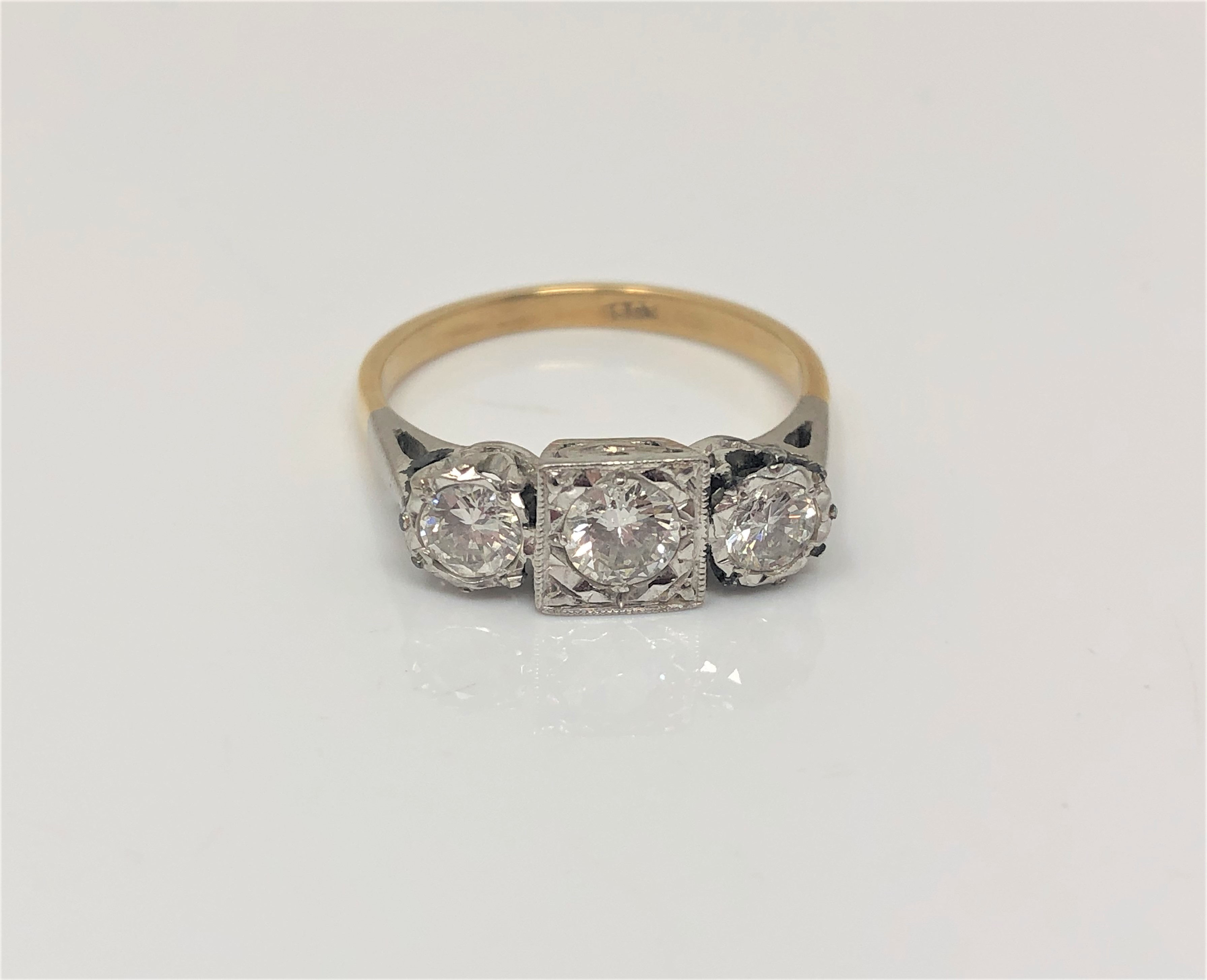 An 18ct gold three stone diamond ring, the three brilliant cut stones approximately 1ct,