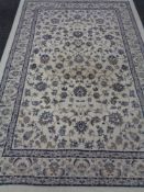 A machine made floral woolen carpet with borders of cream ground
