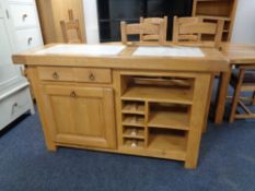 A contemporary oak kitchen island with two travertine inset panels