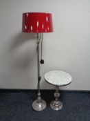 A contemporary metal standard lamp with red shade,