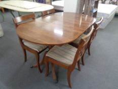 An inlaid yew wood twin pedestal dining table with four chairs