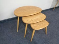 A nest of three Ercol solid elm and beech pebble tables, catalogue no.