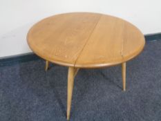 An Ercol solid elm and beech drop leaf folding occasional table, catalogue no.