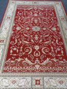 A machine made woolen carpet of floral design on red ground